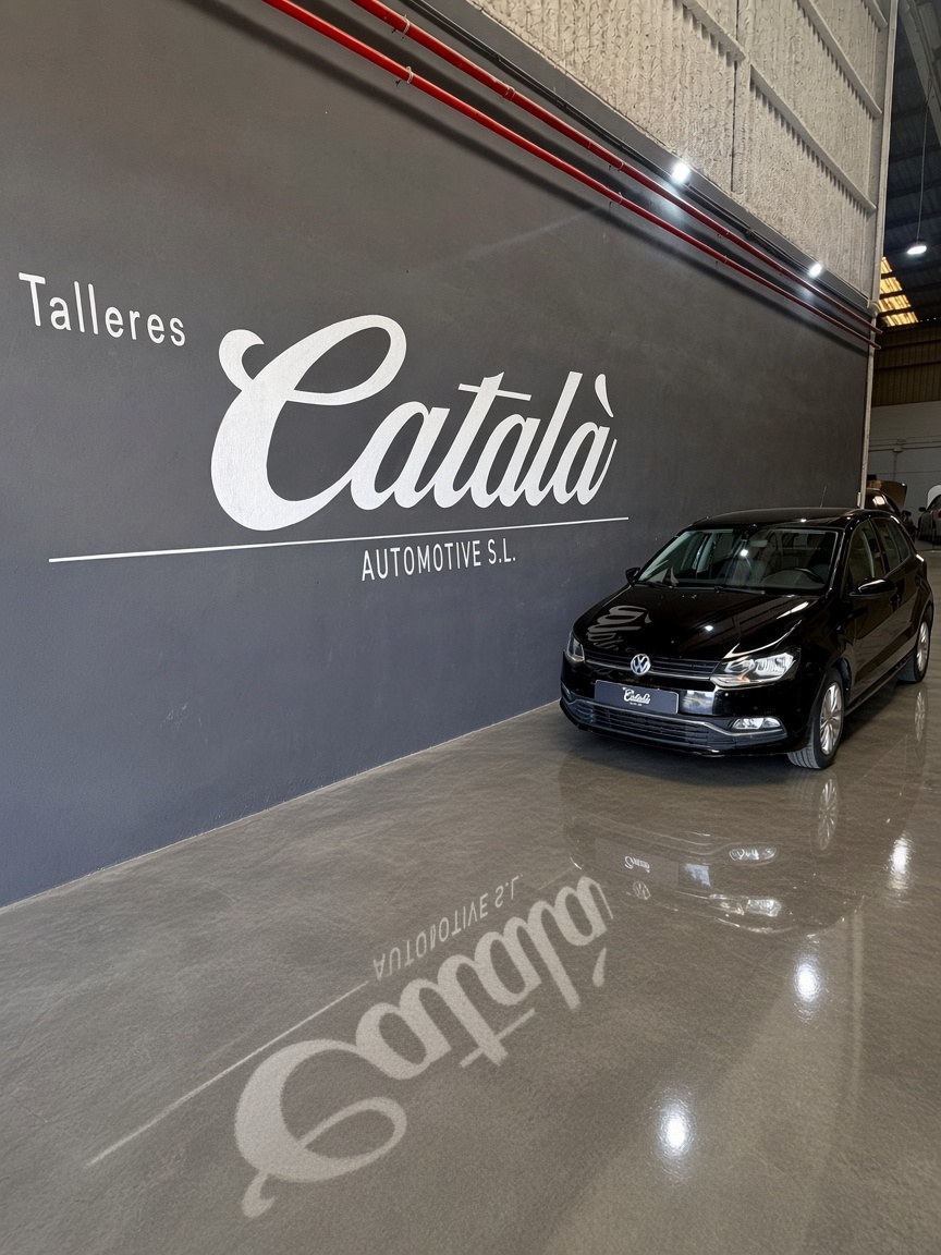 Volkswagen Polo negro frente al logotipo del taller